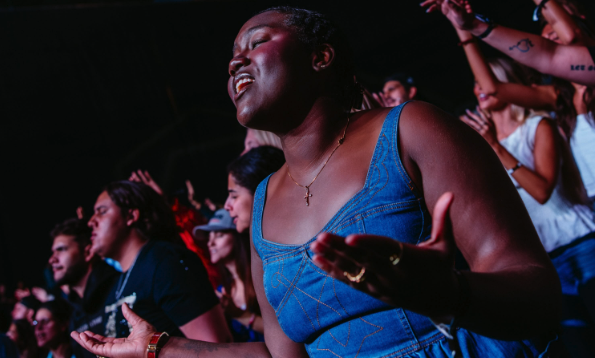 Woman with hands up in a crowd, worshipping
